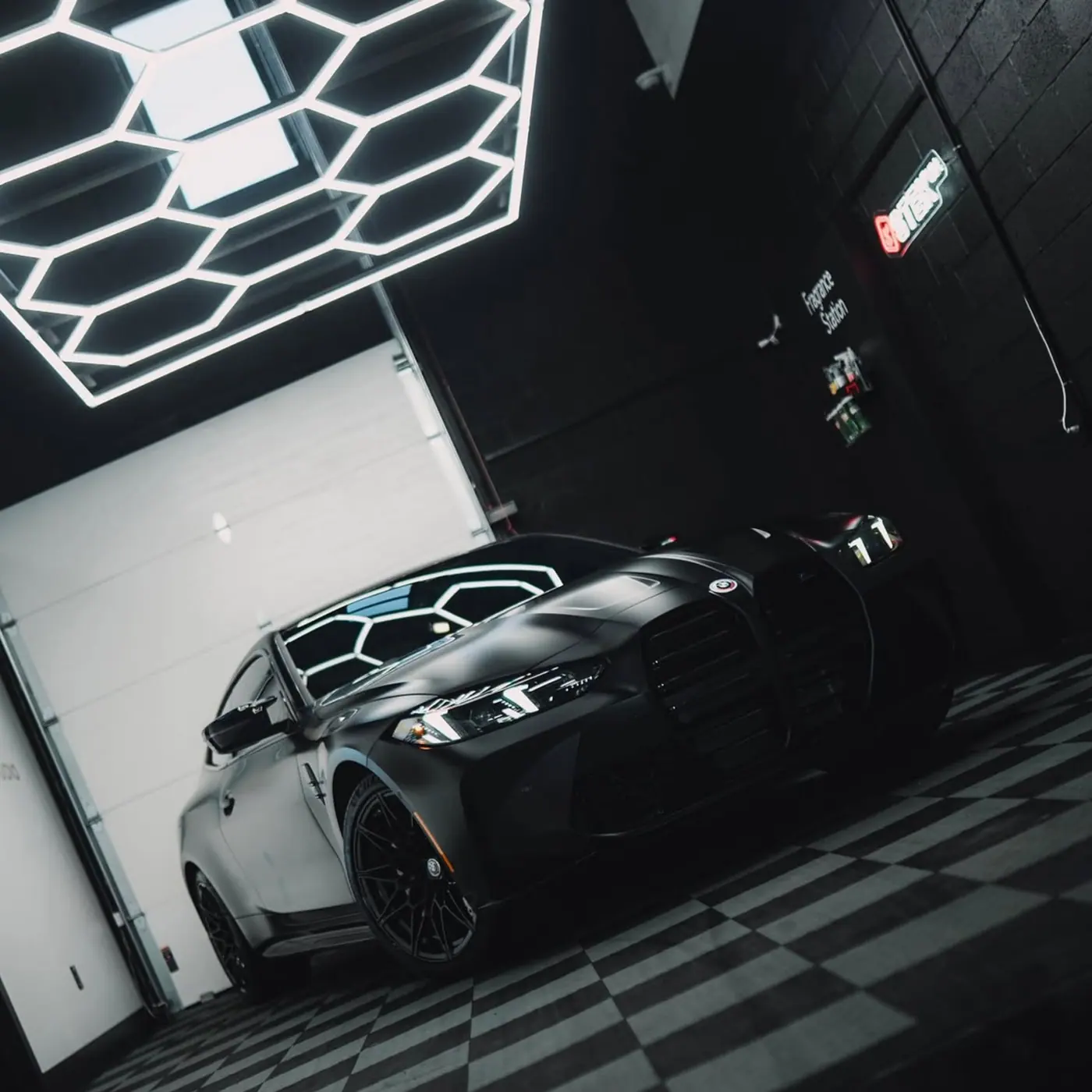 Black BMW under hexagon studio lighting after a full ceramic coating